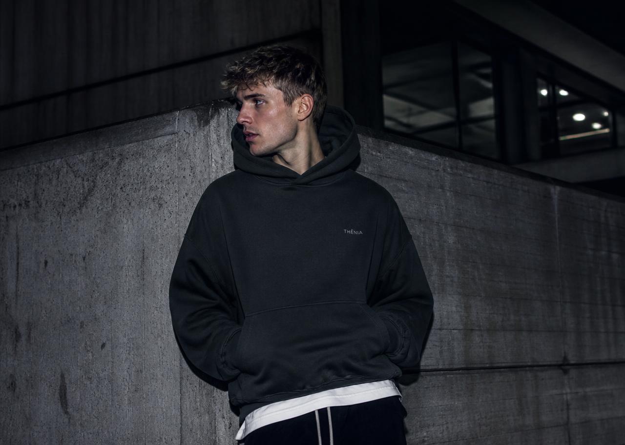 Creator wearing an oversized TWNTY hoodie in SWEDEN at night